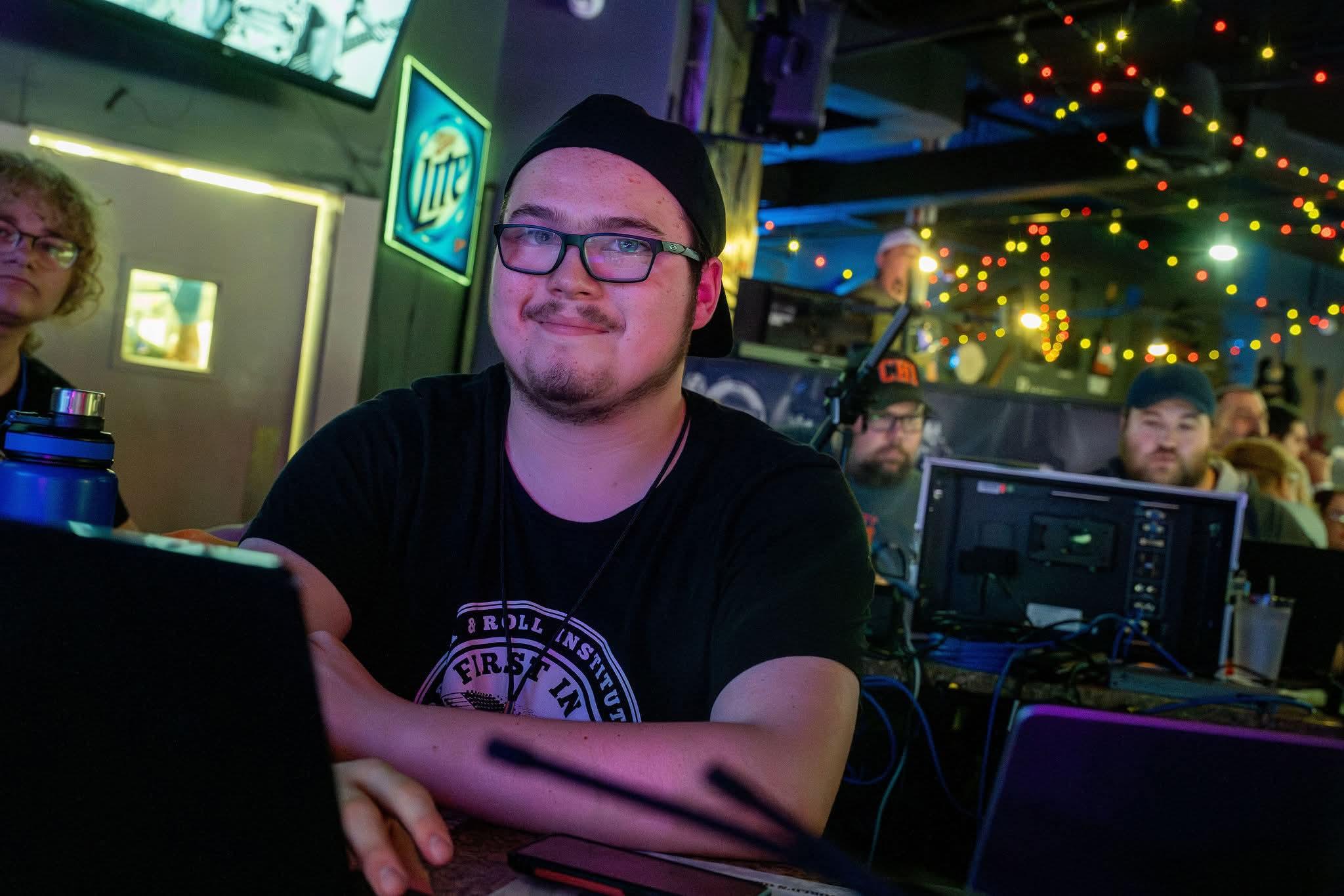 Mason smiling while operating a lighting or audio console during a live show